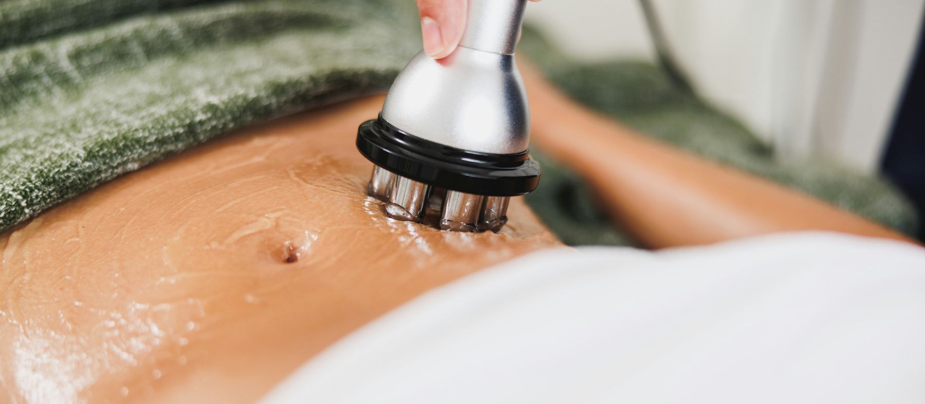 Body contouring treatment being carried out on the abdomen at an aesthetic clinic